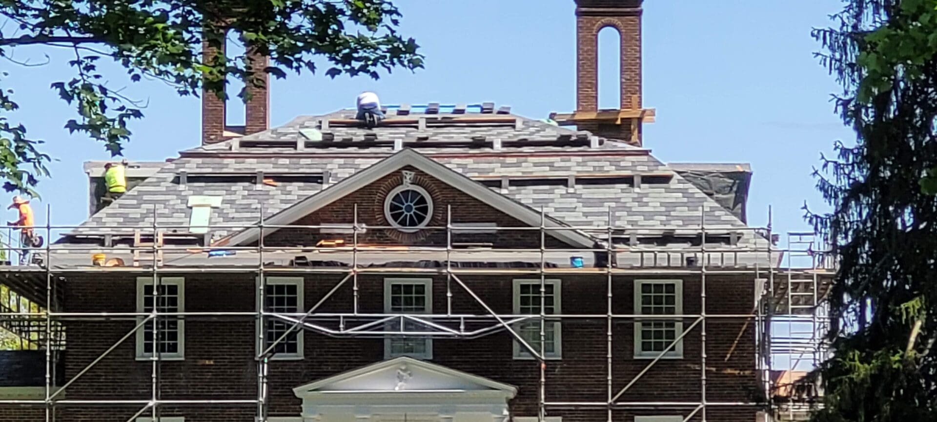 Large slate roof with scaffolding and workers
